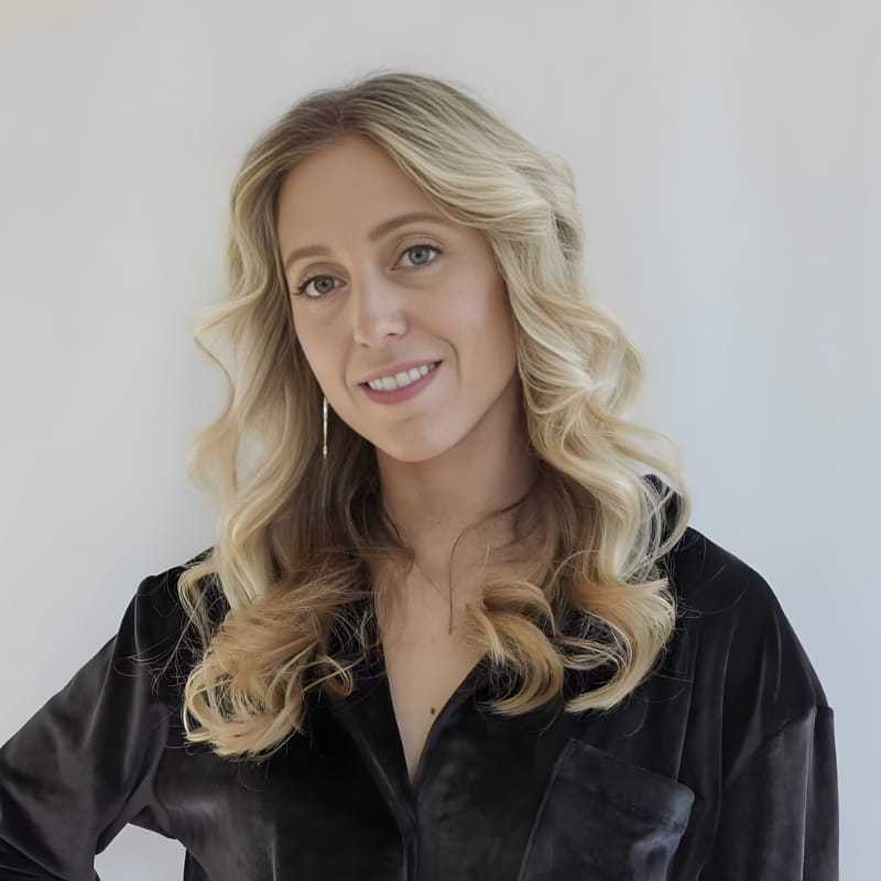 Portrait of Kelly D., a professional stylist at Mouton's Salon, showcasing their expertise and style.