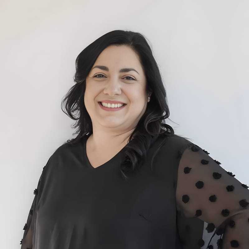 Portrait of Melanie R., a professional stylist at Mouton's Salon, showcasing their expertise and style.