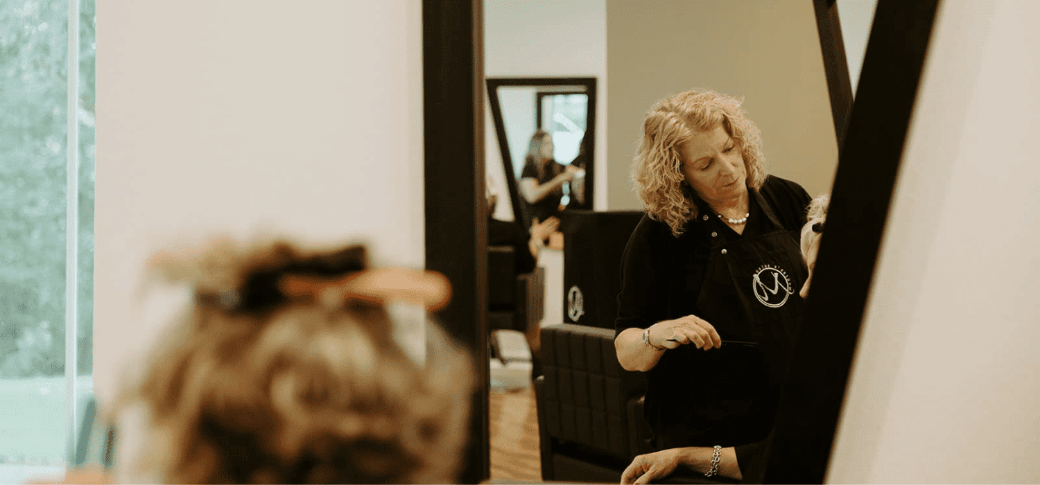 Hairstylist working on a client's hair in a modern salon.